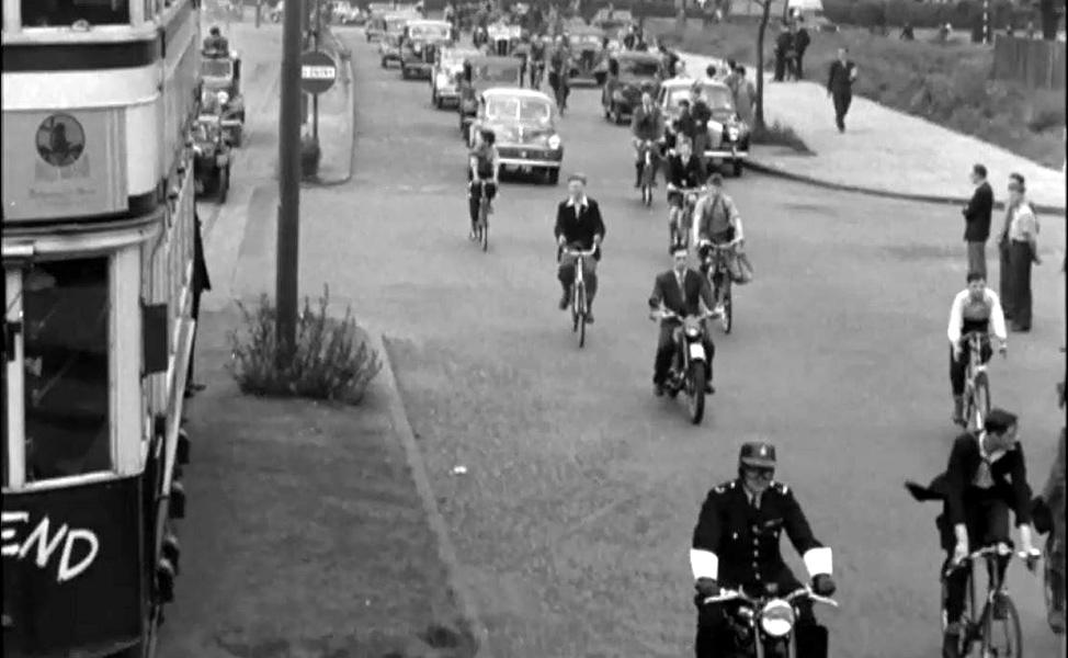 people on bikes following the last tram