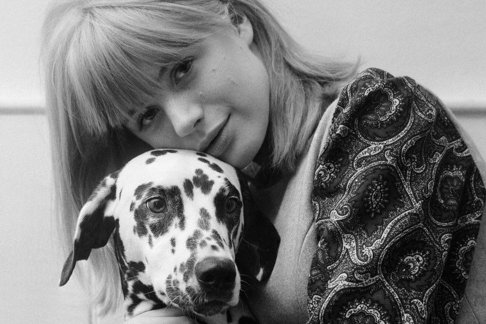 Marianne Faithfull as a young woman posing with a dog