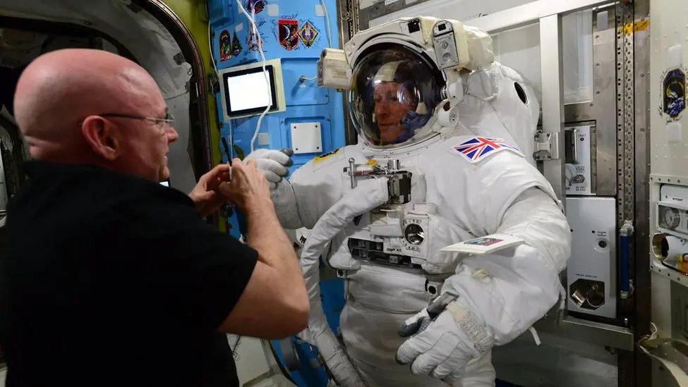 Tim Peak wearing an astonaut outfit with helmet