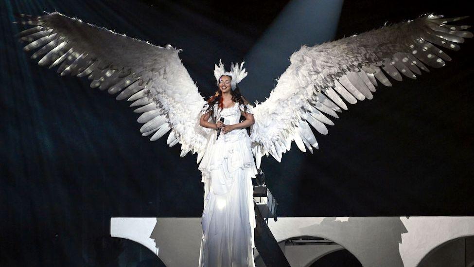 Jade Thirlwall in a white gown and giant angel wings