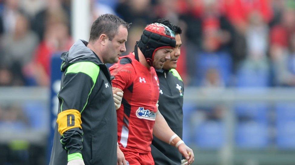 Leigh Halfpenny is helped off after taking a blow playing for Wales against Italy in Rome