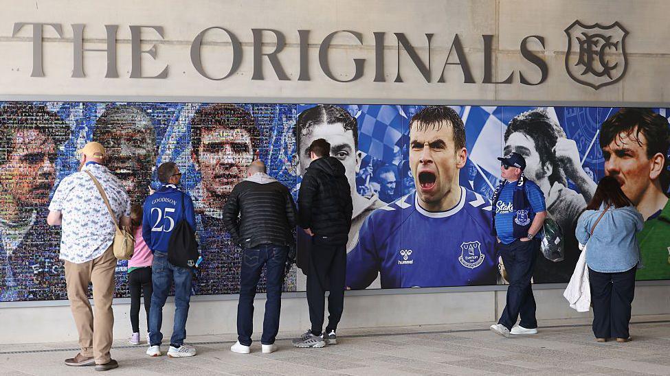 Everton fans stand by a mosaic of heamus Coleman and other club legends at Hill Dickinson Stadium