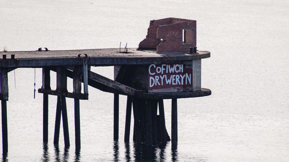 A sign reading "Cofiwch Dryweryn" (meaning "Remember Tryweryn") at the end of a jetty on September 21, 2021 in Milford Haven, Wales. The phrase has become associated with Welsh nationalism and independence political movements.