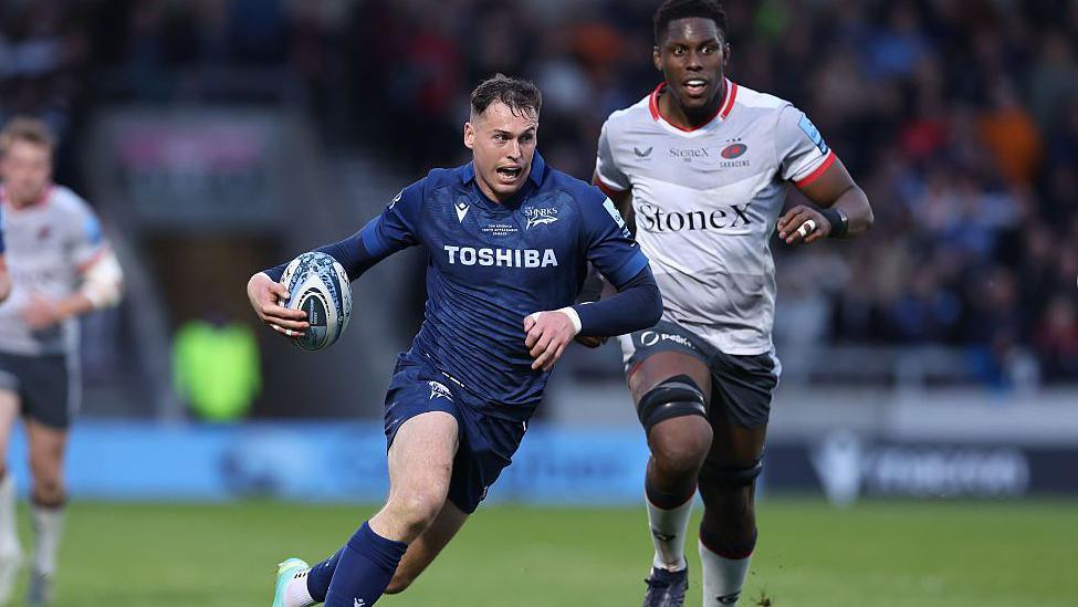 Tom Roebuck carries the ball and leads a break for Sale against Saracens