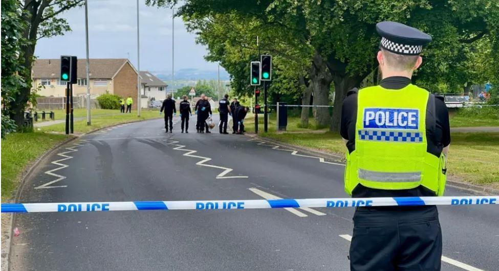 Police line and officer on Middleton Ring Road in Beeston Park with another group of police officers in the distance investigating the site where a 19-year-old was hit by a car and killed on Friday.