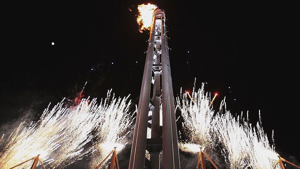 The flame is lit at the 2006 Winter Paralympics as fireworks go off