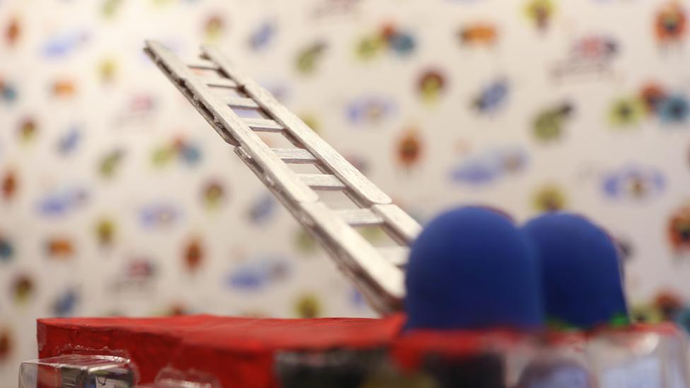 The ladder on top of the fire engine raised in the air.