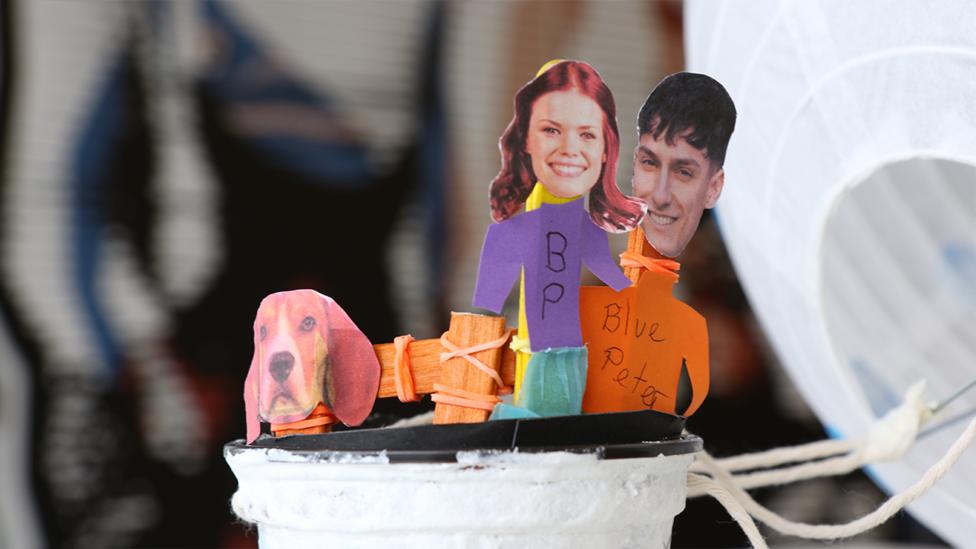 A close-up of the models of Lindsey, Richie and Henry in the basket of the hot air balloon.