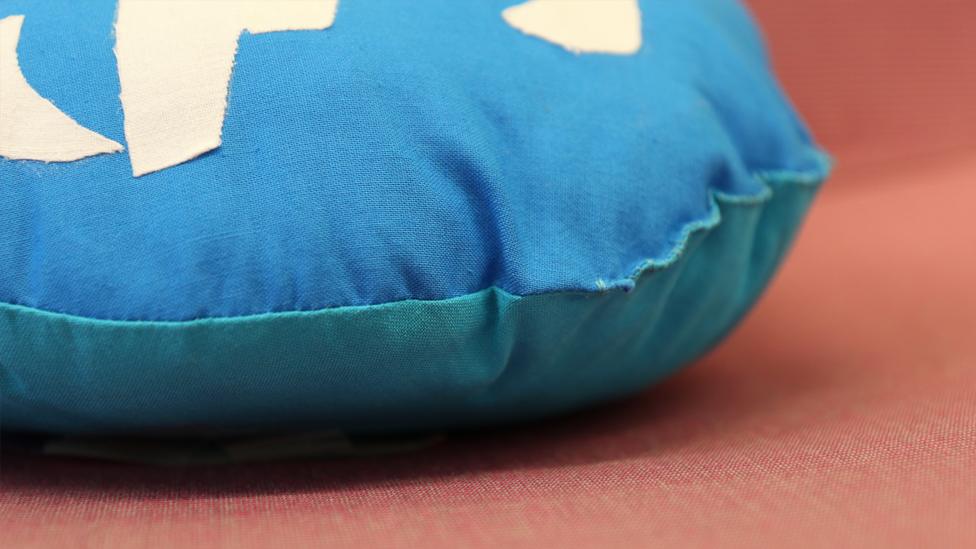 A close-up of the stitching on the edge of the cushion.