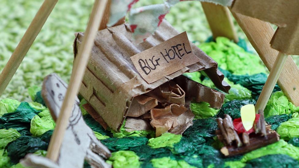 A close-up of the Bug Hotel, made from corrugated cardboard, with a little sign.