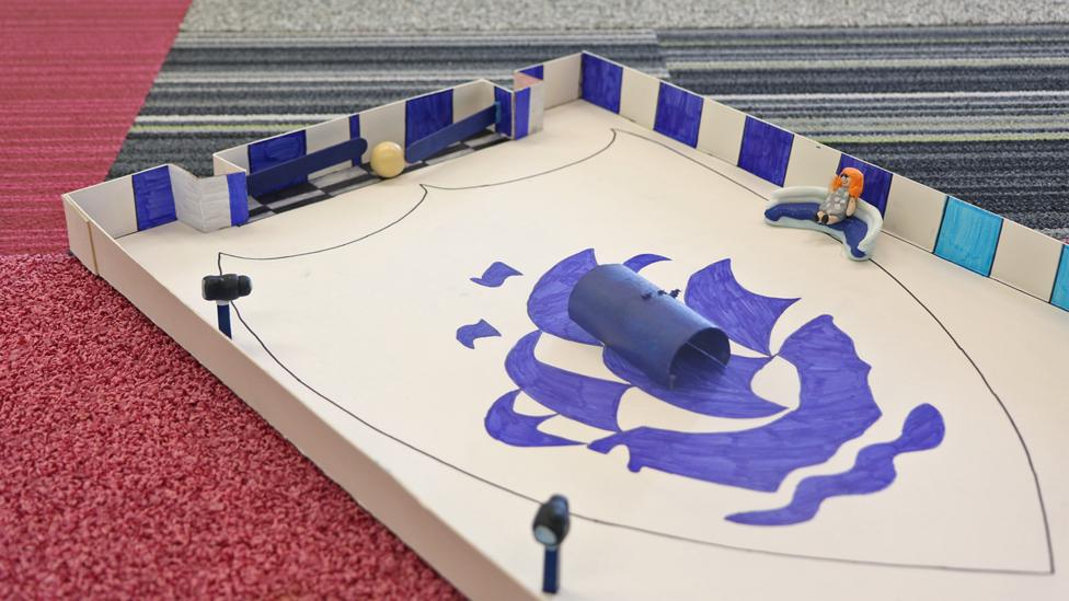 Looking down on the whole of the pinball game, with the BP ship drawn in the centre, cameras around the edge, and Lindsey sat on the BP sofa.