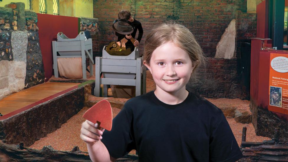 girl-smiling-holding-up-a-tool-for-digging.