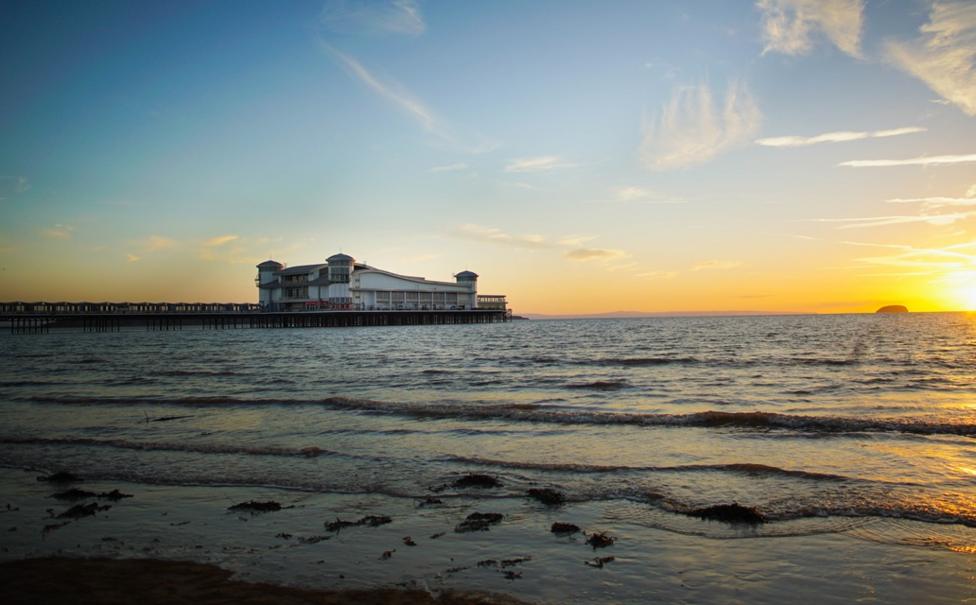 A view of the Grand Pier across the sea, during a sunset.