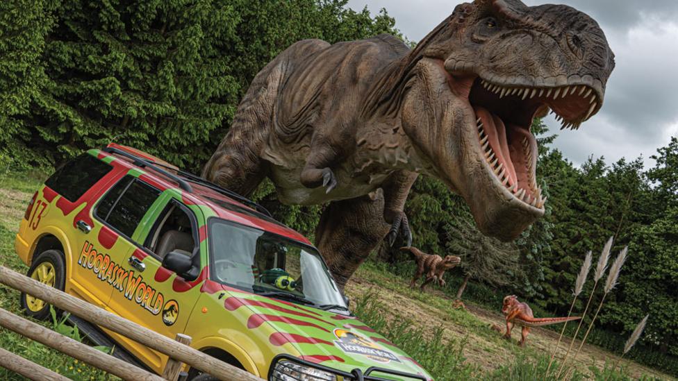 t-rex_towering_over_jeep.