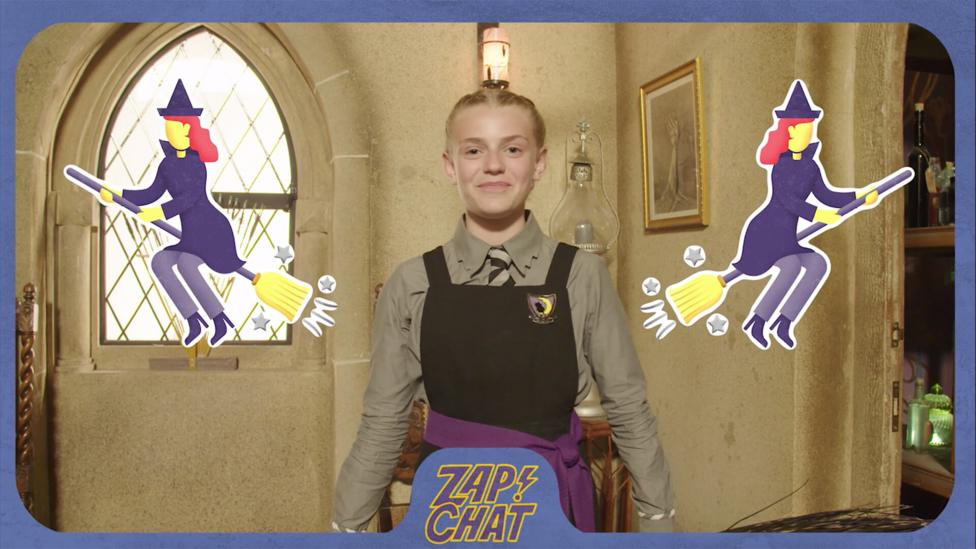 A young witch (Sybil) in Cackle's Academy uniform grinning beside two witches on brooms emojis.