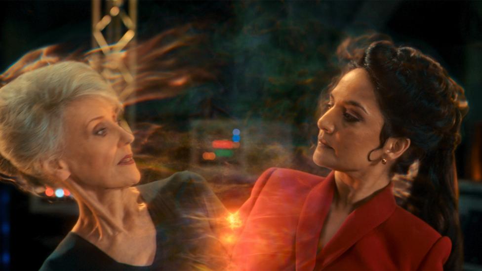 Mrs Flood bi-generates into the Rani, two women pulling apart from each other.