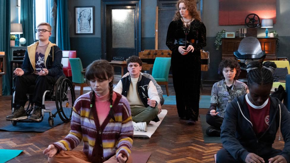 Image of Gifted characters sitting on the floor practicing meditation.