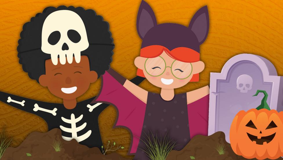 A young boy with an afro is wearing a skeleton costume next to a young ginger girl wearing a bat costume. Next to them is a cartoon gravestone and a pumpkin.