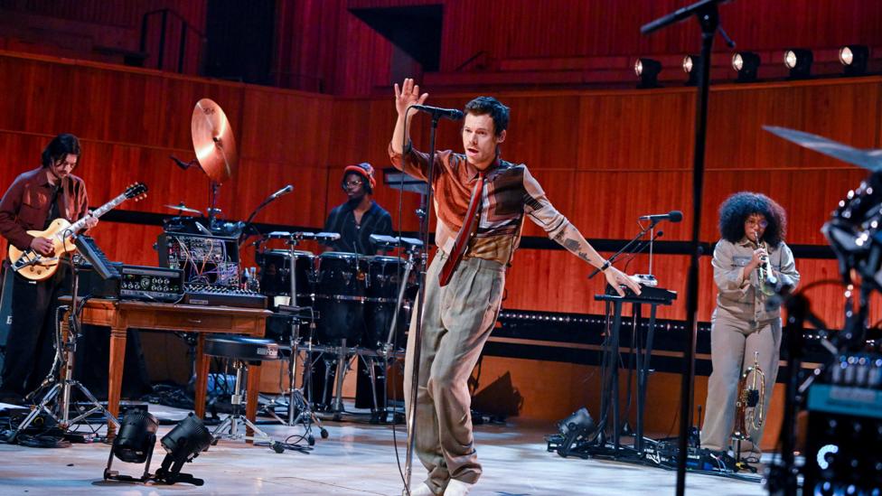 Harry Styles dances on stage in front of his live band