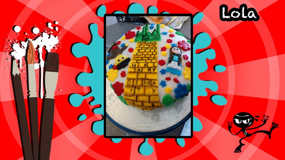 A birthday cake decorated with a picture inspired by the Wizard of Oz's yellow brick road.