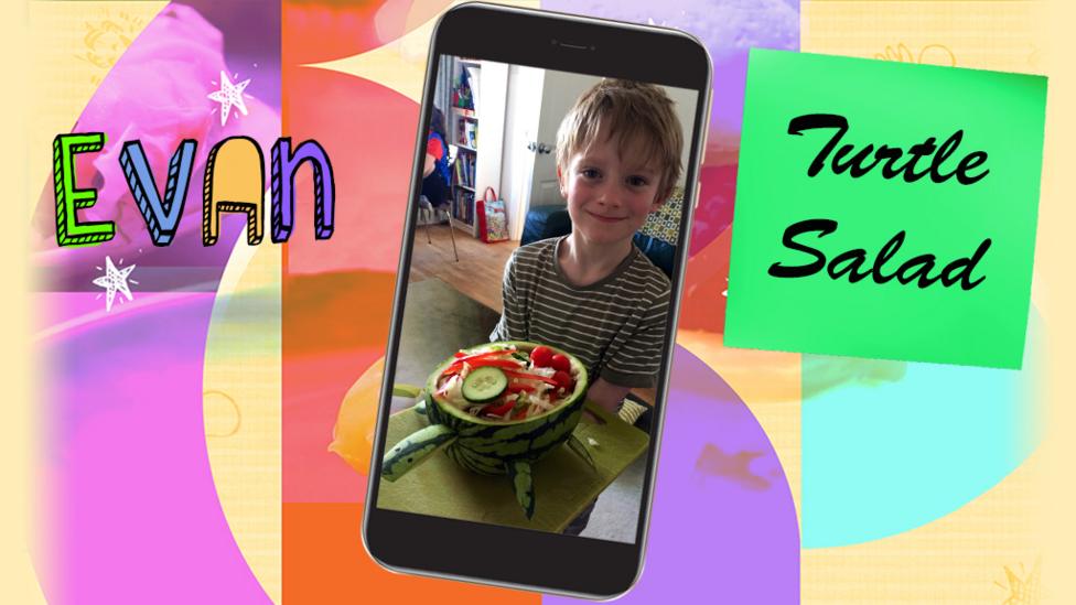 A little boy (Evan) smiling and holding up a watermelon-turtle salad bowl.