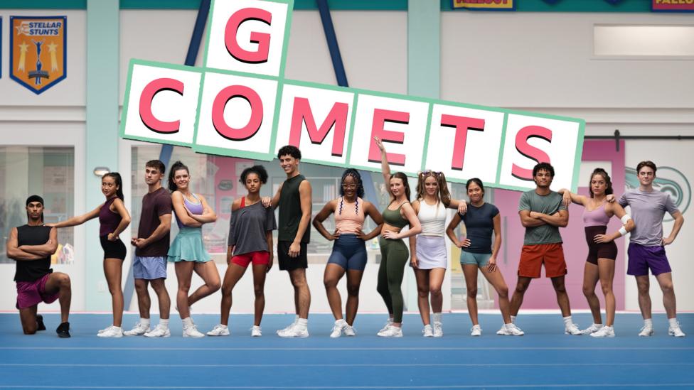 Image of a cheer squad posing on a mat in a gym hall with the words 'Go Comets' behind them in crossword format.