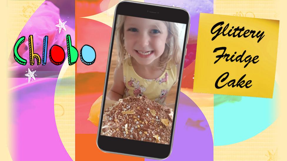 A girl (Chlobo) smiling and holding a plate containing a glittery fridge cake.
