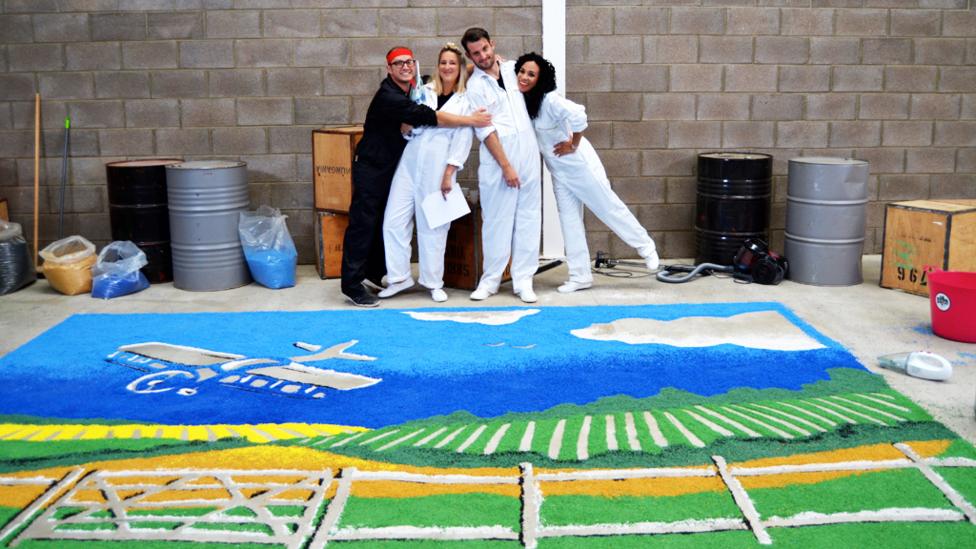 Ricky and his friends by a giant picture.