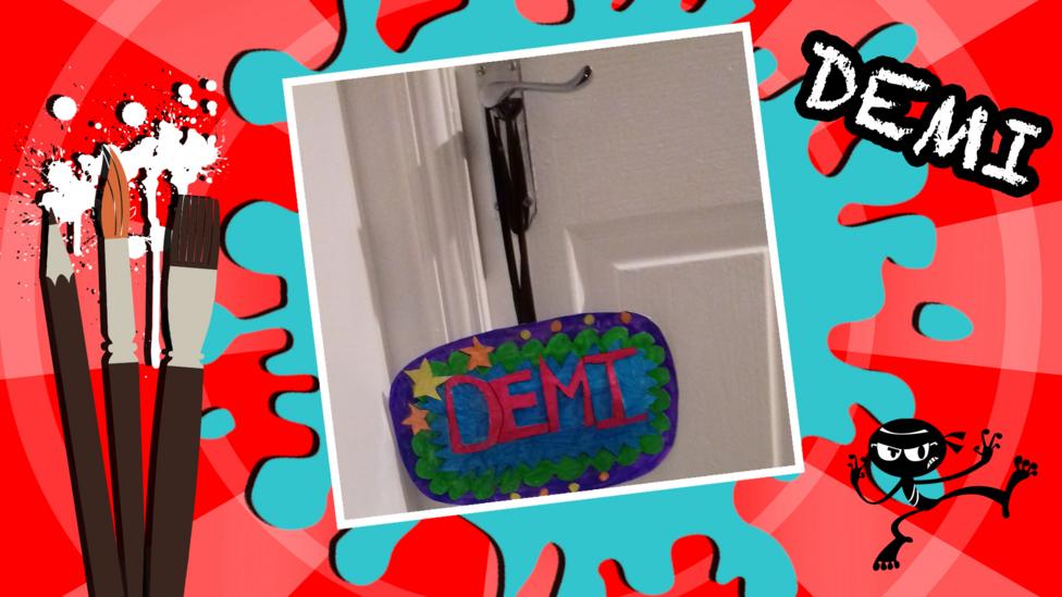 A pop art room sign for a door handle, which says 'Demi'.
