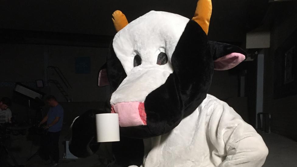 Gav in a cow costume with a mug.