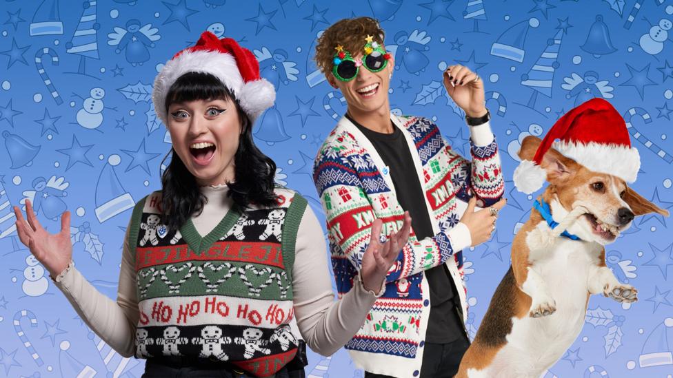 Abby, Joel and Henry in christmas hats and jumpers on a christmas patterned background.