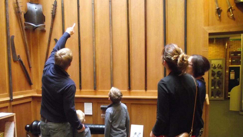 Family looking at a collection of ancient weapons