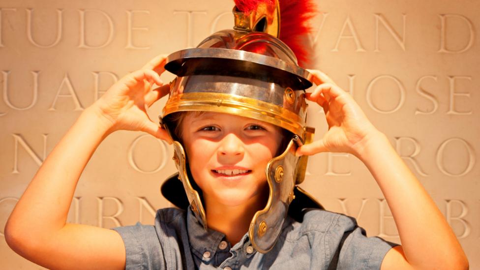 Child wearing a Roman helmet