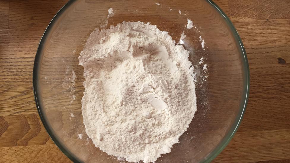 A bowl with flour, salt and baking powder.