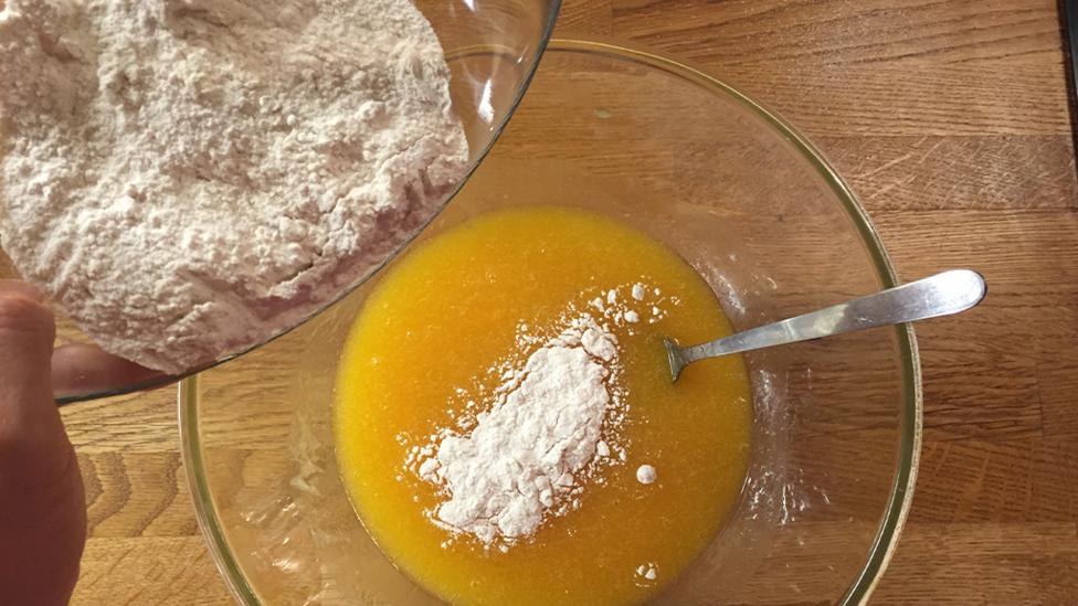 Mixing flour into the butter and egg mixture.