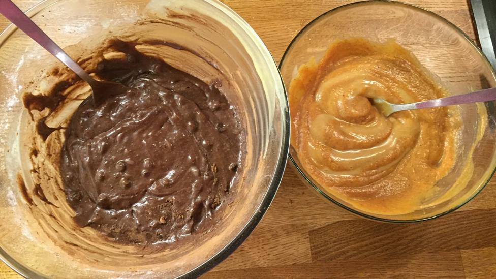 Two bowls of batter, one with chocolate and one with pumpkin.