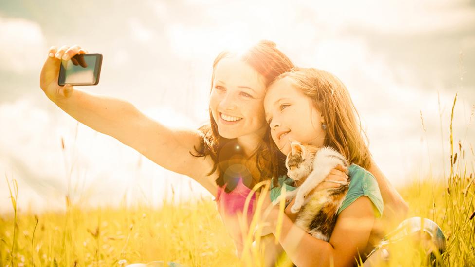 Mum and daughter taking a selfie with their kitten.