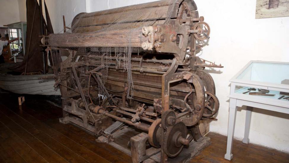 An old piece of nautical machinery, with netting over it