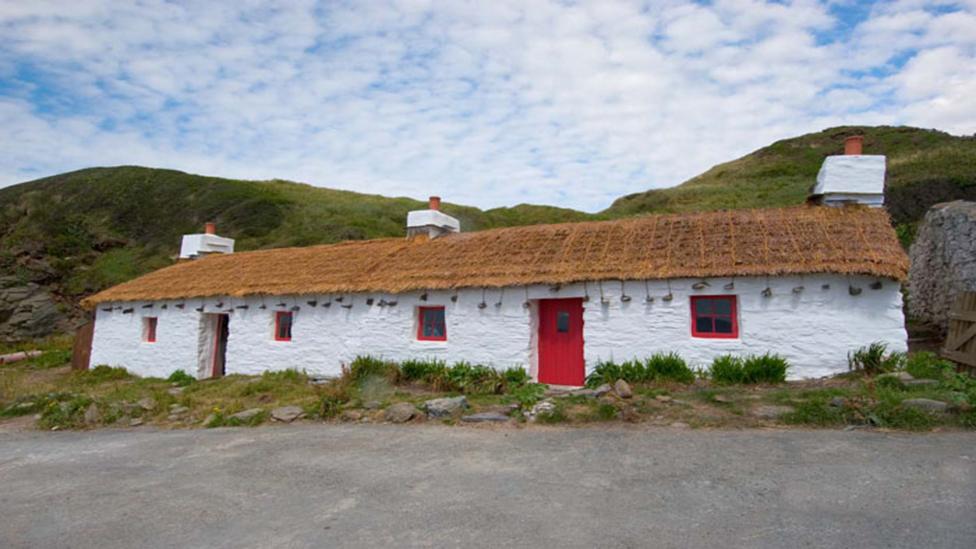 A white cottage with thatched roof at Niarbyl