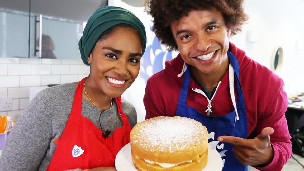 Nadiya Hussain with Radzi Chinyanganya, holding a Victoria sponge cake.