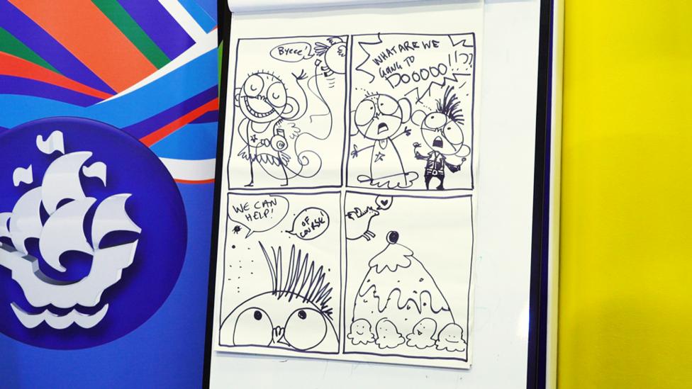 Four comic strip panels on a flipchart: a monkey drying its hair with a hairdryer; two monkeys saying "what are we going to do?!"; some fleas saying "we can help!"; a pony flying over a giant cheesecake.