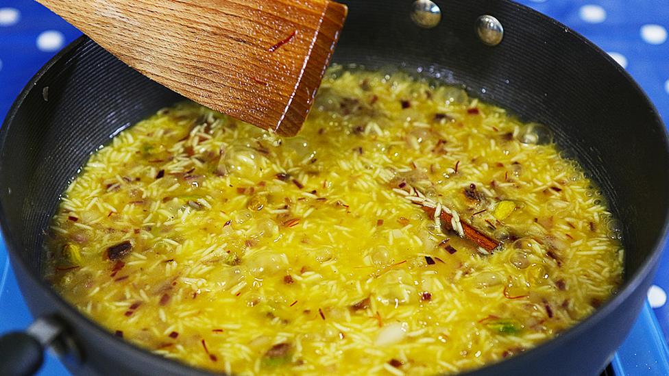 Biryani cooking in a pan.