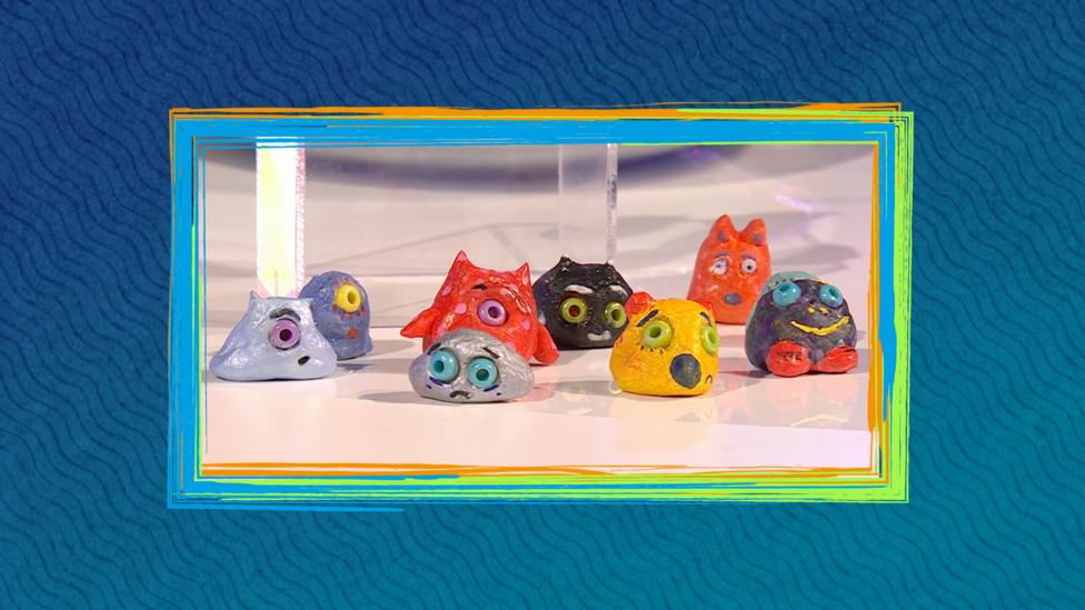 Small clay characters with faces on a blue background