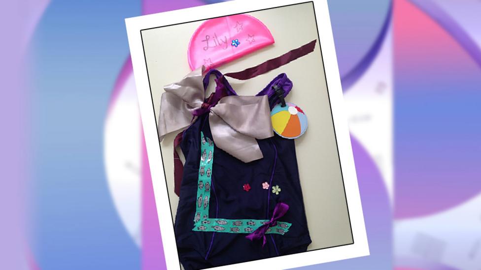 A purple velvet swimming costume embellished with ribbons and bows.