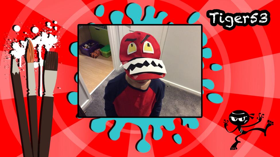 A picture of a boy wearing a monster cap.