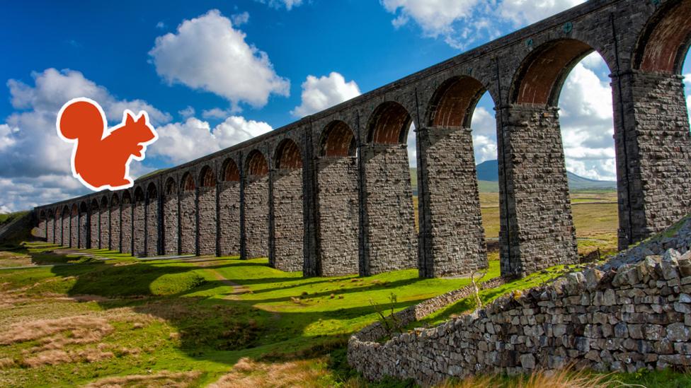 The Ribblehead Viaduct arches against a bright blue sky, with an orange red squirrel outline.