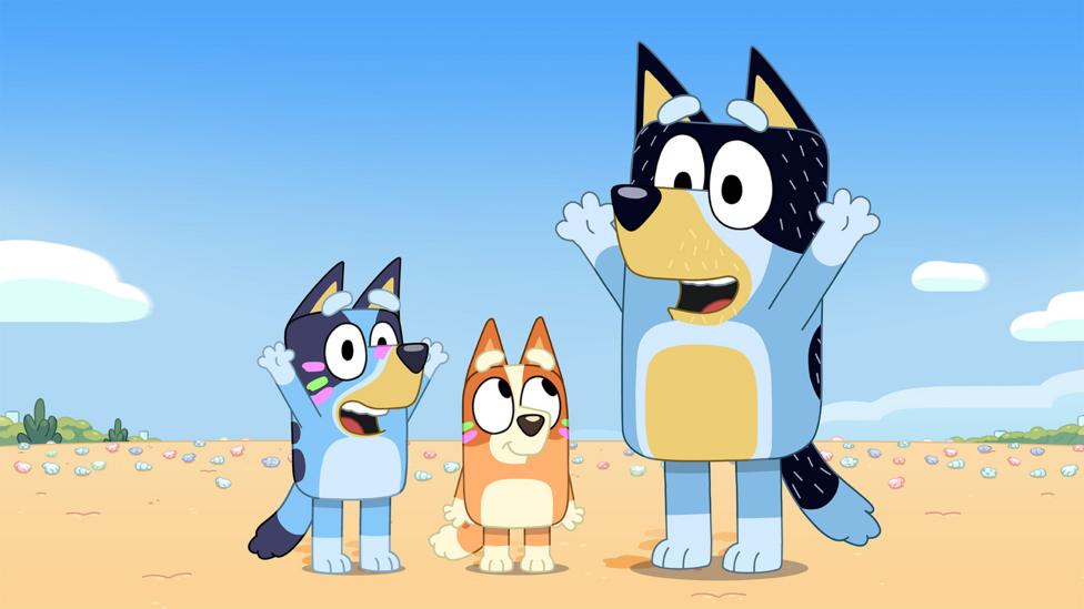 Bluey, Bingo and Dad wearing face paint on the beach