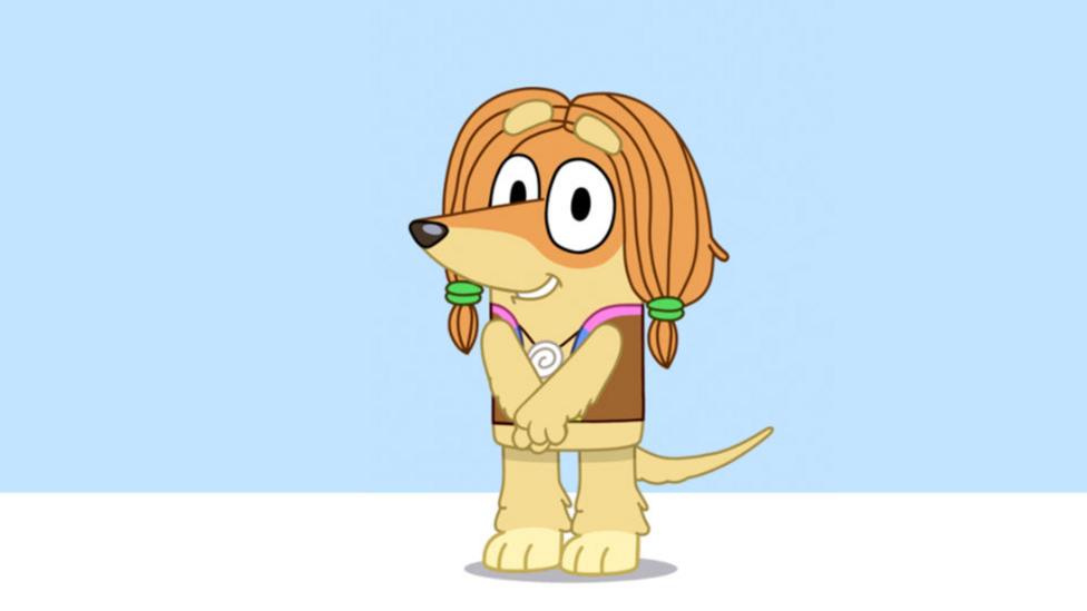 A tan cartoon Afghan Hound, wearing a hippy vest with her long hair in pig tails around her face.