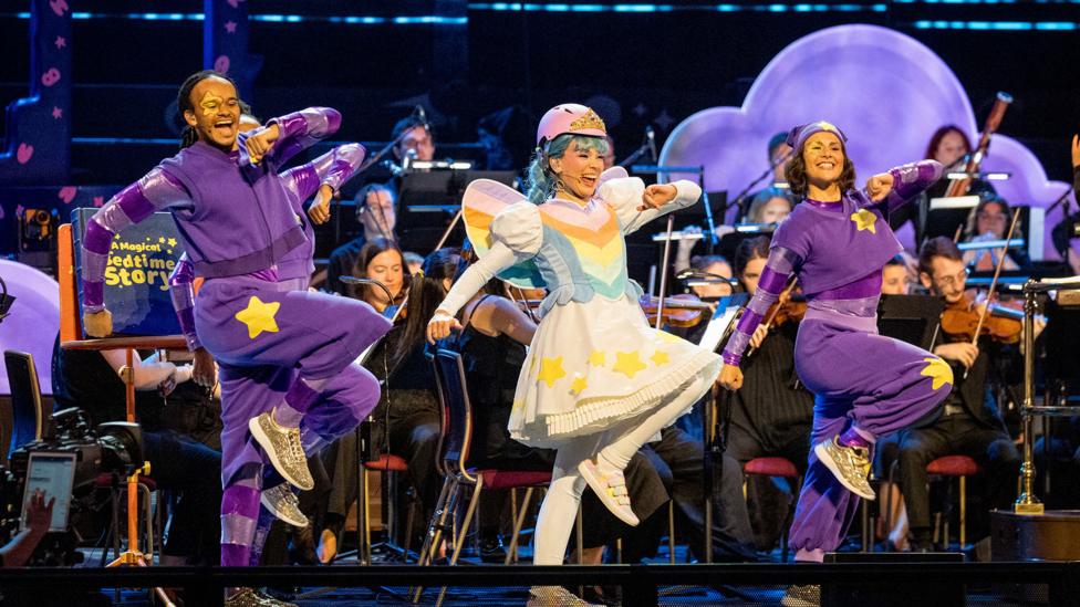Story Fairy and two Story Helpers dance in unison onstage.