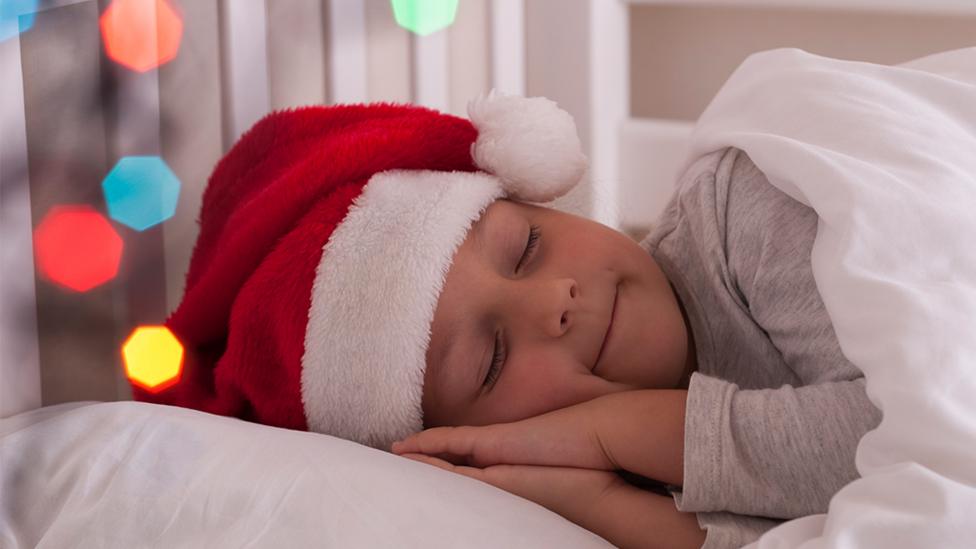 Child sleeping in a Christmas hat